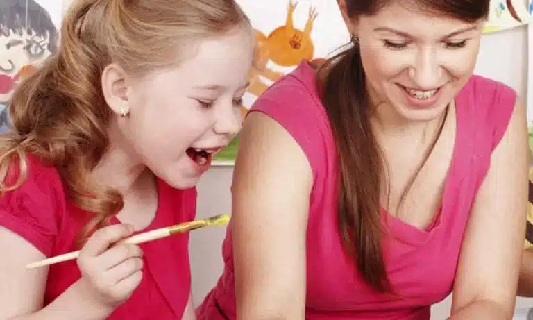 Niña estudiando con su maestra