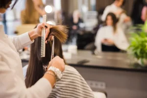 Mujer cortando el cabello de una señora